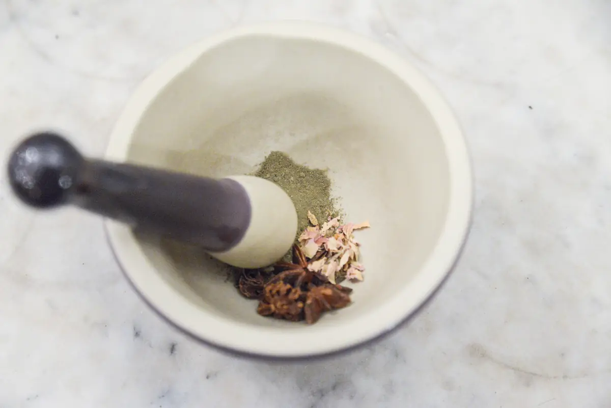 Vermalen: vijzel met kruiden en gedroogde bloemen