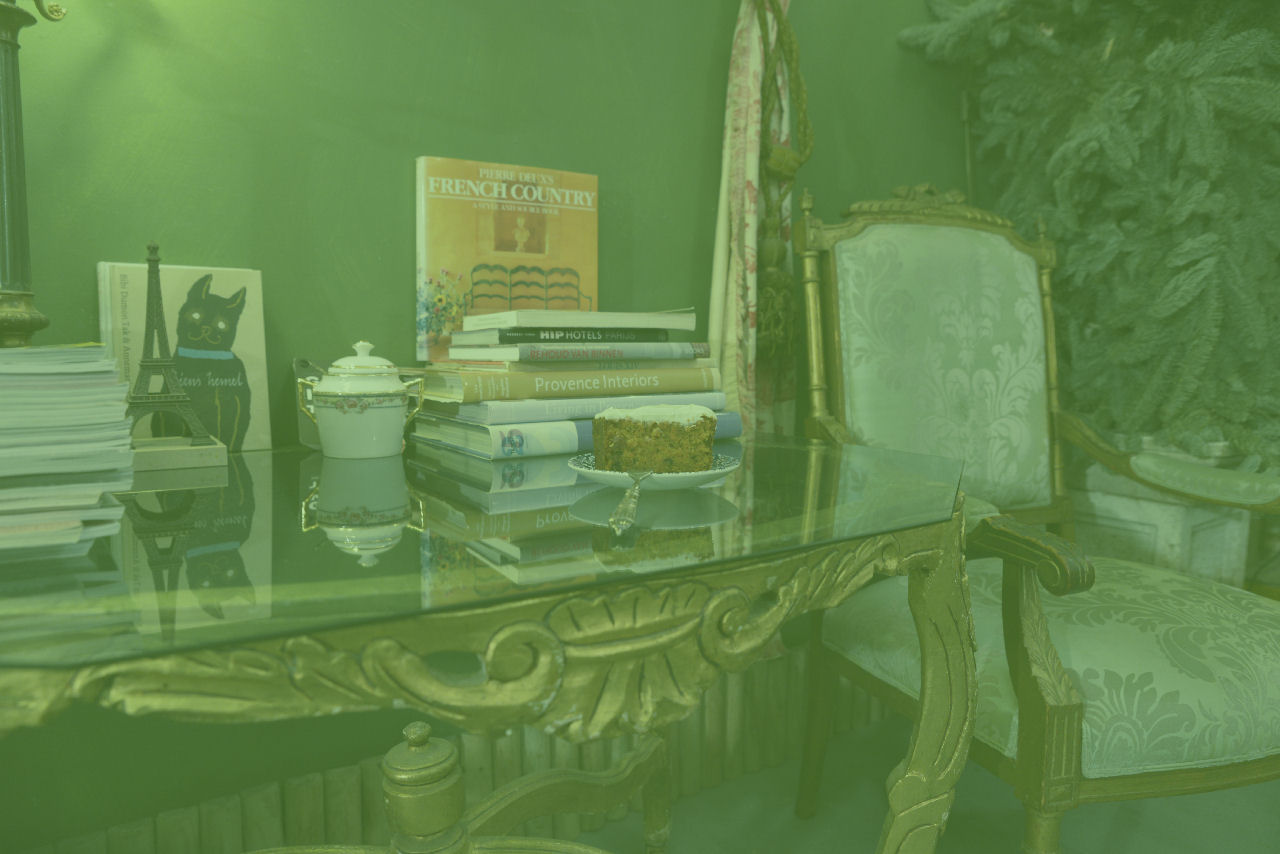 Ornamentale salontafel met kunstboeken en gebak in Huis van Groen